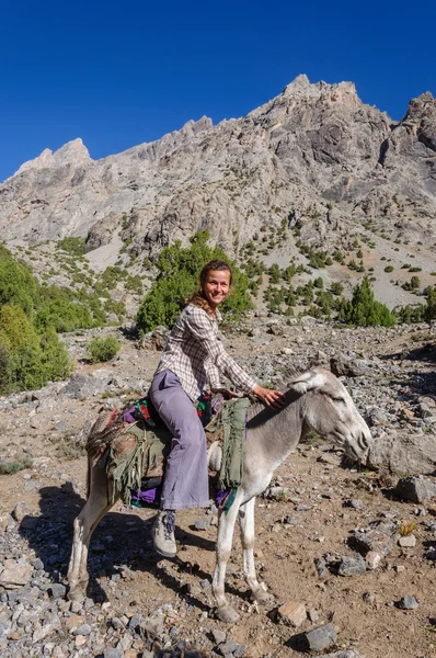 Woman riding on donkey in the mountain — Stock Photo, Image