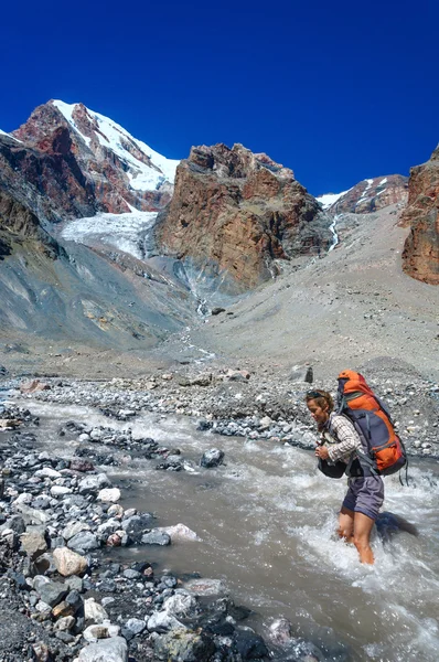 Chica joven cruzando río de montaña —  Fotos de Stock