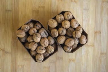 Sert kabuklarda cevizler, kahverengi karton kutularda kurumuş meyveler, pişirmeye ve pişirmeye hazır sağlıklı gıda malzemeleri.