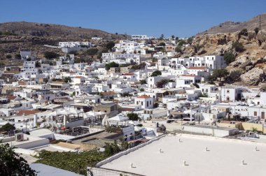 Lindos 'un genel görünümü, bir grup beyaz ev, Akropolis' in güçlendirilmiş kalesi, mavi gökyüzü