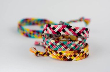 El yapımı el yapımı renkli doğal dokuma bilezikler açık beyaz arka planda izole edilmiş arkadaşlık bilezikleri.