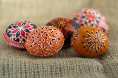 Ev yapımı balmumu ve boyalı Paskalya yumurtaları jute tekstil bej arka plan, doğu zamanı dekorasyonu, beş renkli nesne.