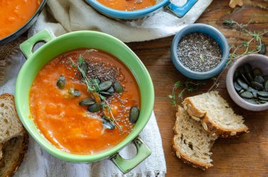 Kabak çekirdeği ve chia ile sonbahar balkabağı çorbası, kırsal ahşap masadan atılmış.