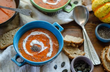 Kabak çekirdeği ve chia ile sonbahar balkabağı çorbası, kırsal ahşap masadan atılmış.