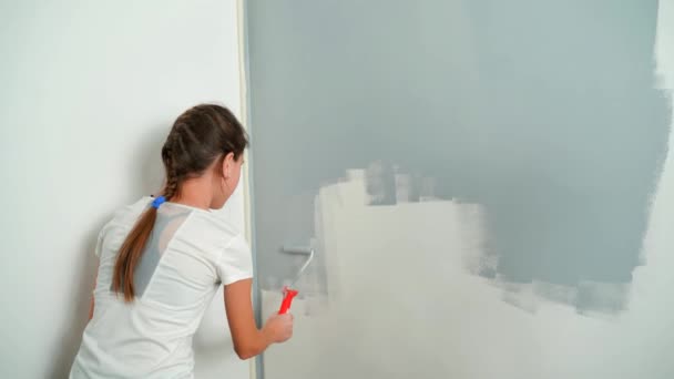 A young girl paints the wall with a roller gray. Room Renovations at Home. — Stock Footage A young girl paints the wall with a roller gray. Room Renovations at Home. Royalty Free Stock Video