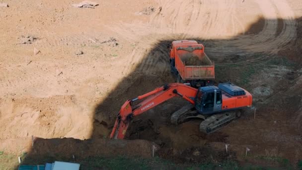 Cheboksary, September 23, 2020. The excavator digs the ground and loads it into a dump truck. Site preparation for the construction of a residential building. — Stock Footage Cheboksary, September 23, 2020. The excavator digs the ground and loads it into a dump truck. Site preparation for the construction of a residential building. Royalty Free Stock Footage