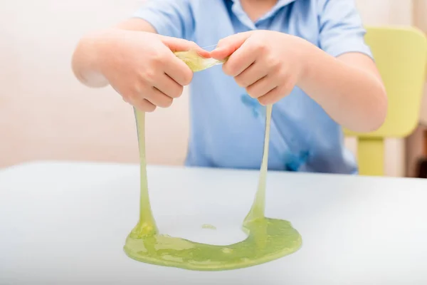 Mucus in the hands of a child sitting at a table — Stock Photo, Image