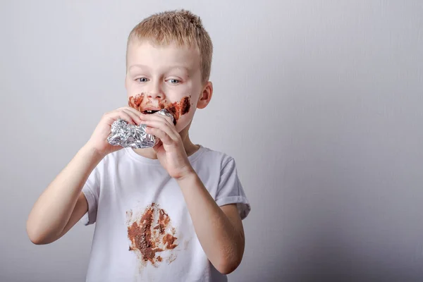 Junge Isst Grinsend Eine Tafel Schokolade Und Verschmiert Kleidung Hochwertiges — Stockfoto
