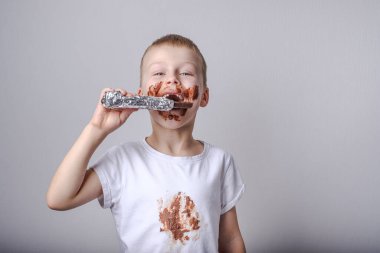 Elbiselerinde leke olan çikolata yiyen çocuk kıyafetlerdeki lekeleri temizleme kavramı. - Evet. Yüksek kalite fotoğraf