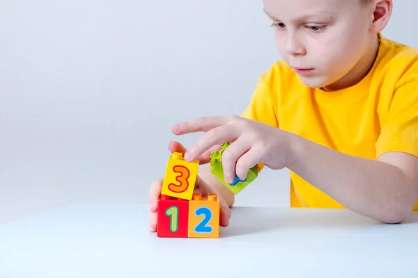 Barnet Leker Med Kuber Med Siffror Bordet Vit Bakgrund Begreppet — Stockfoto