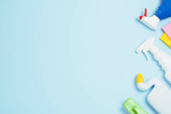 Detergents and cleaning accessories for different surfaces kitchen, bathroom and other rooms.Empty place for text or logo blue background.Cleaning service concept. Top view. High quality photo