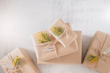 Sarı çiçeklerle süslenmiş hediye kutuları. Bir teşekkür hediyesi. Konsepti takdir ediyorum. Beyaz arka planda izole edilmiş, üst görünümde. Yüksek kalite fotoğraf