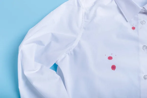 blood stain on clothes. isolated on blue background. top view. High quality photo