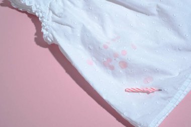 Kirli mum lekesi kıyafetlere damlıyor. Pembe arka planda izole. Üst Manzara. Yüksek kalite fotoğraf