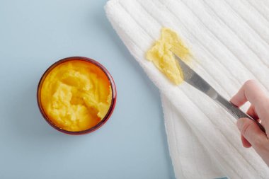 Giysilerdeki vücut fırçası lekesi. Bıçaklı el, beyaz havluları temizler. en üstteki görünüm