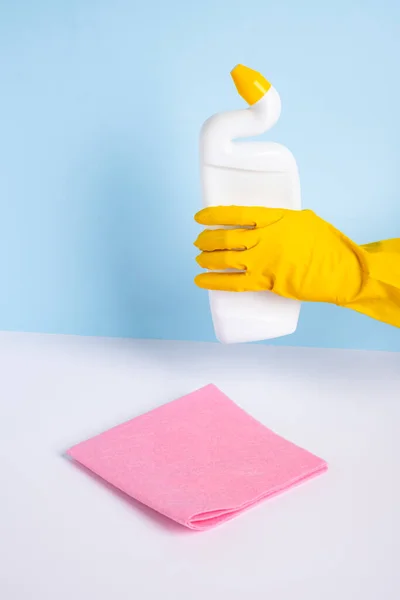 Mano de mujer en guante protector de goma amarilla que sostiene medios para la desinfección de un inodoro. Limpieza e higiene en la casa. — Foto de Stock