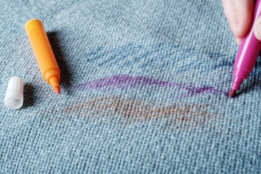 Çocuk eli kanepenin kumaşına pembe bir keçeli kalem çizer. Günlük hayat, temizlik ve temizlik için kirli bir leke. Yüksek kalite fotoğraf