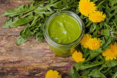 Kırsal ahşap arka planda cam bir kavanozda sağlıklı karahindiba pesto. Yüksek kalite fotoğraf