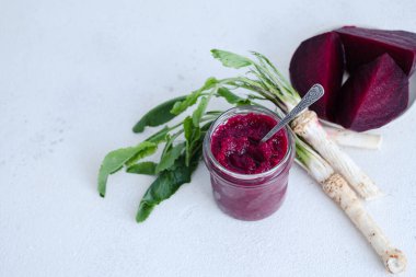 Bir kavanoz ev yapımı pancar turpu humusu. Ortasında bir kaşıkla. Beyaz arka planda izole edilmiş organik yiyecekler. Üst Manzara. Yüksek kalite fotoğraf