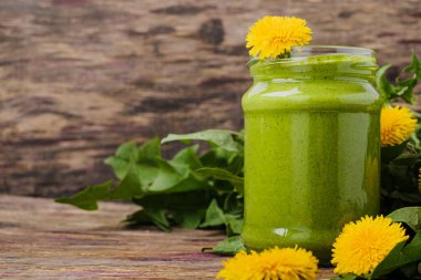 Kırsal ahşap arka planda cam bir kavanozda sağlıklı karahindiba pesto. Yüksek kalite fotoğraf