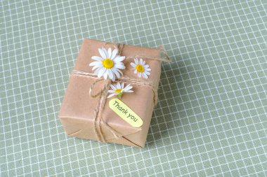 Evde masanın üzerinde, bir hücredeki masa örtüsüne sarılı eko-hediye. Yüksek kalite fotoğraf. Yüksek kalite fotoğraf