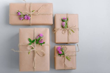  Kahverengi el işi kağıdıyla sarılmış ve yonca çiçekleriyle süslenmiş hediye kutuları. en üstteki görünüm 