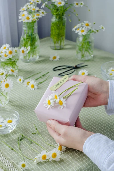 Weibliche Hände Halten Ein Mit Kamillenblüten Verziertes Geschenk Mit Worten — Stockfoto