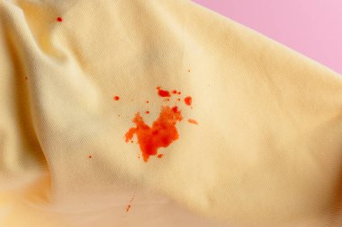 juice spilling on yellow clothes. daily life dirty stain for wash and clean concept. isolated on pink background. High quality photo