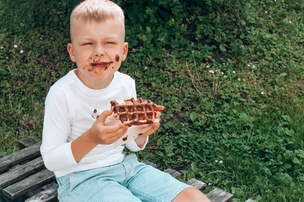 Mladý nepořádný chlapec s čokoládou na tváři — Stock fotografie