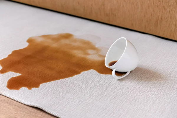 Spilled coffee on a white carpet. The concept of cleaning stains. High quality photo