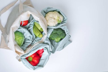 Beyaz bir masada tekstil alışveriş poşetlerinde taze sebzeler, sıfır atık kavramı. Düz yatıyordu. Metin için boşluk. Üst Manzara. - Evet. Yüksek kalite fotoğraf