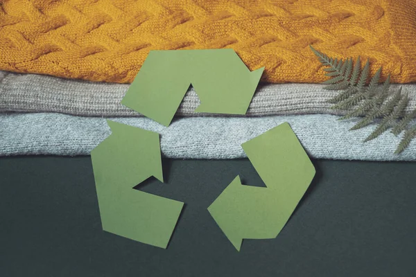 Cartel de reciclaje cortado de cartón en la pila de ropa de otoño. Reciclar concepto de ropa. — Foto de Stock