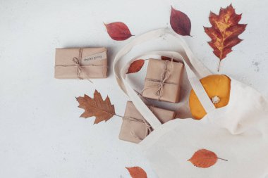 Sonbahar balkabağı, hediye, alışveriş poşetinde düşmüş yapraklar beyaz arka planda, üst tarafta izole edilmiş. Sonbahar kompozisyonu. Şükran Günü, sonbahar konsepti.