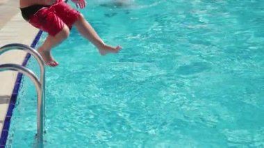 Çocuk havuza atlıyor.