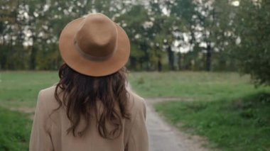 Şapkalı kadın yürüyor.