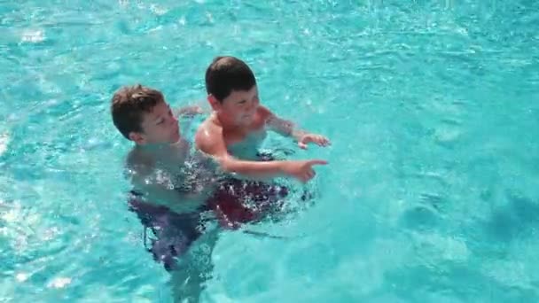 Crianças relaxando na piscina — Vídeo de Stock