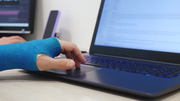 Fiberglass cast hand uses laptop — Stock Video
