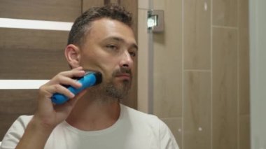 Adam yanağını tıraş ediyor.