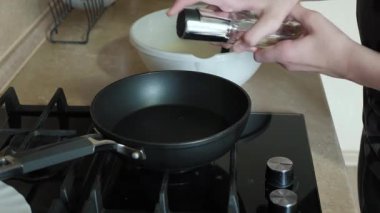 Pişirmeden önce tavaya yağ ekleme süreci.