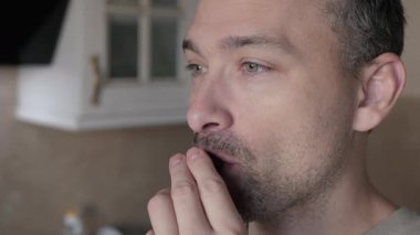 Adam, yüz ifadelerini ve elinde tuttuğu nefis çikolatalı tatlıyı vurgulayan yakın plan çekimleri sayesinde dejenere olmuş siyah çikolatanın tadını çıkarıyor.