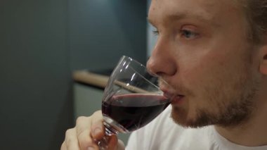 Cömert kırmızı şarabın tadını çıkaran genç adam, yaklaşın.