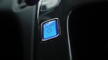 Parlayan mavi bir araba düğmesi. Şoför arabayı kapatmak için düğmeye bastığında parlak arka ışık kararır. Gösterge panelindeki aydınlatma düğmesi arabanın hazır olduğunu gösteriyor.