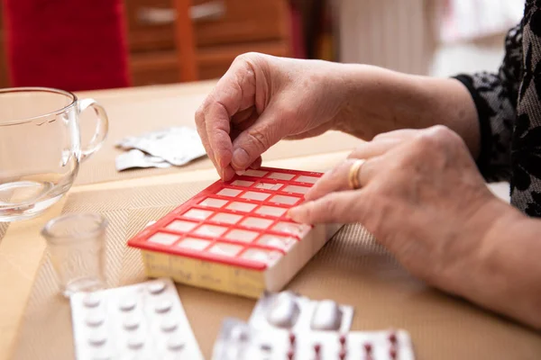 Older women taking medications at table, Senior woman preparing pills , prepare daily medicine tablet in pillbox
