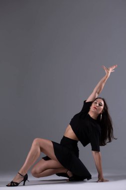 Genç profesyonel dansçı stüdyoda çalışıyor, siyah elbiseli genç kadın dans ediyor, dansçı.