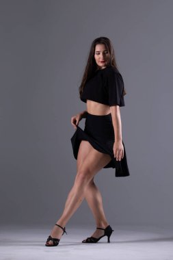 Genç profesyonel dansçı stüdyoda çalışıyor, siyah elbiseli genç kadın dans ediyor, dansçı.