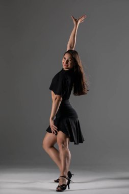 Genç profesyonel dansçı stüdyoda çalışıyor, siyah elbiseli genç kadın dans ediyor, dansçı.