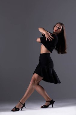 Genç profesyonel dansçı stüdyoda çalışıyor, siyah elbiseli genç kadın dans ediyor, dansçı.