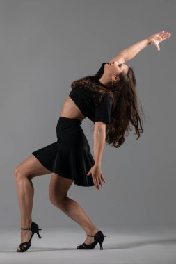 Genç profesyonel dansçı stüdyoda çalışıyor, siyah elbiseli genç kadın dans ediyor, dansçı.