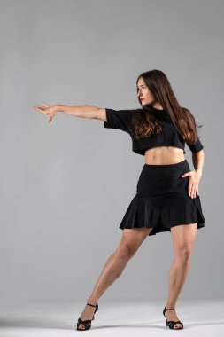 Genç profesyonel dansçı stüdyoda çalışıyor, siyah elbiseli genç kadın dans ediyor, dansçı.