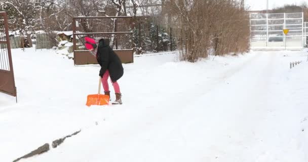 女人用铲子清扫道路 开始像吉他一样弹奏铲子 一个有趣的女人拿着雪铲和雪铲跳舞 — 图库视频影像